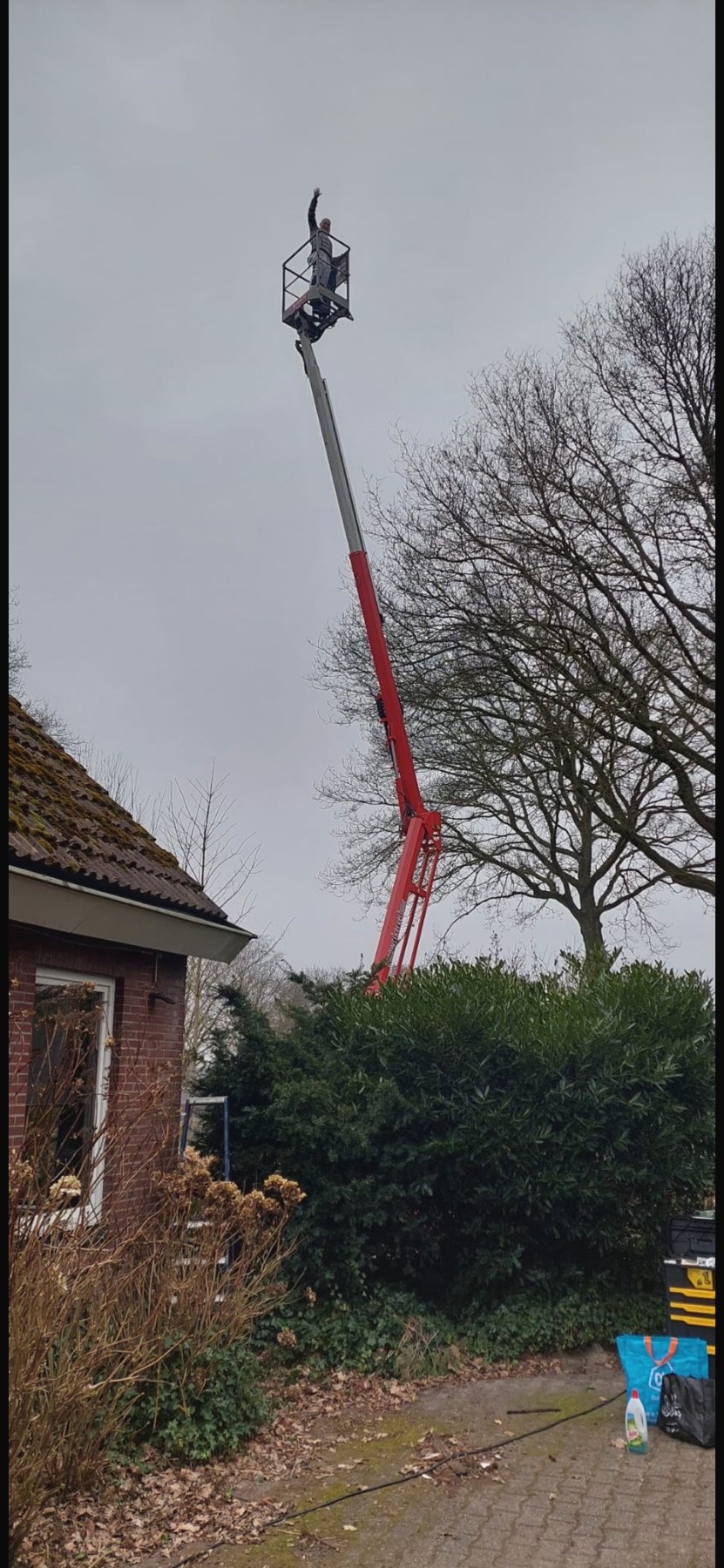 Amber Schilderwerken aan het werk op een hoogwerker